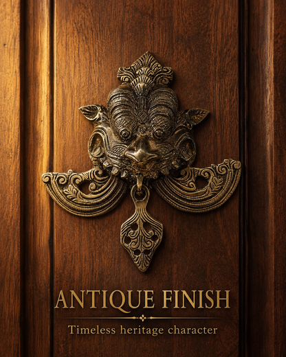 An ornate antique-style metal door knocker with a gargoyle or demon face and scrollwork, mounted on a dark brown wooden door. Gold text at the bottom reads 'ANTIQUE FINISH' with the subtitle 'Timeless heritage character'.
