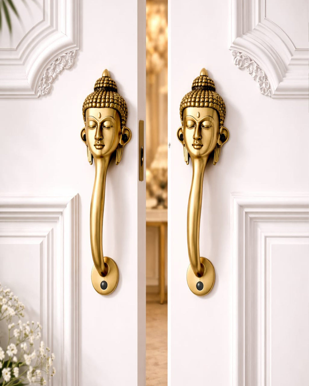 Buddha face brass door handle on a open white door.