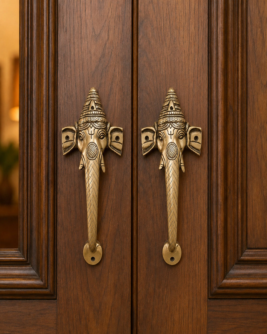 Decorative brass elephant handles on a wooden door.