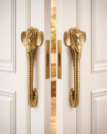 Golden Ganesha door handles on a white door.