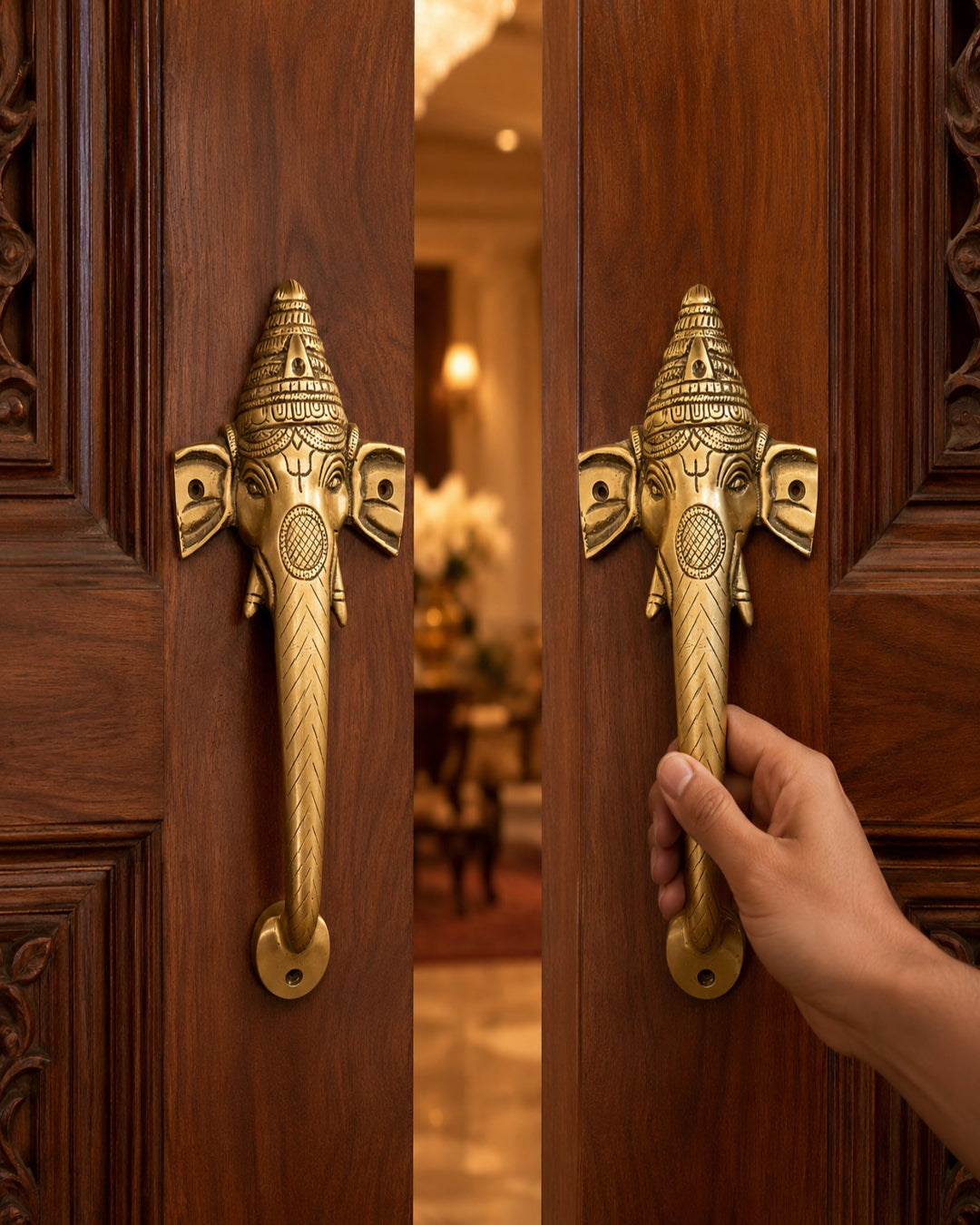 Decorative brass door handle shaped like an elephant on a wooden door, with a hand about to open it.