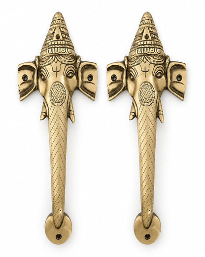 Two ganesha brass door handles on a white background.