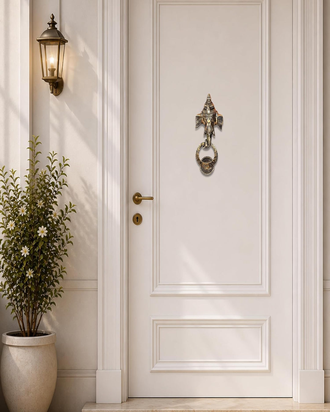 White door with decorative knocker and light fixture on a wall.