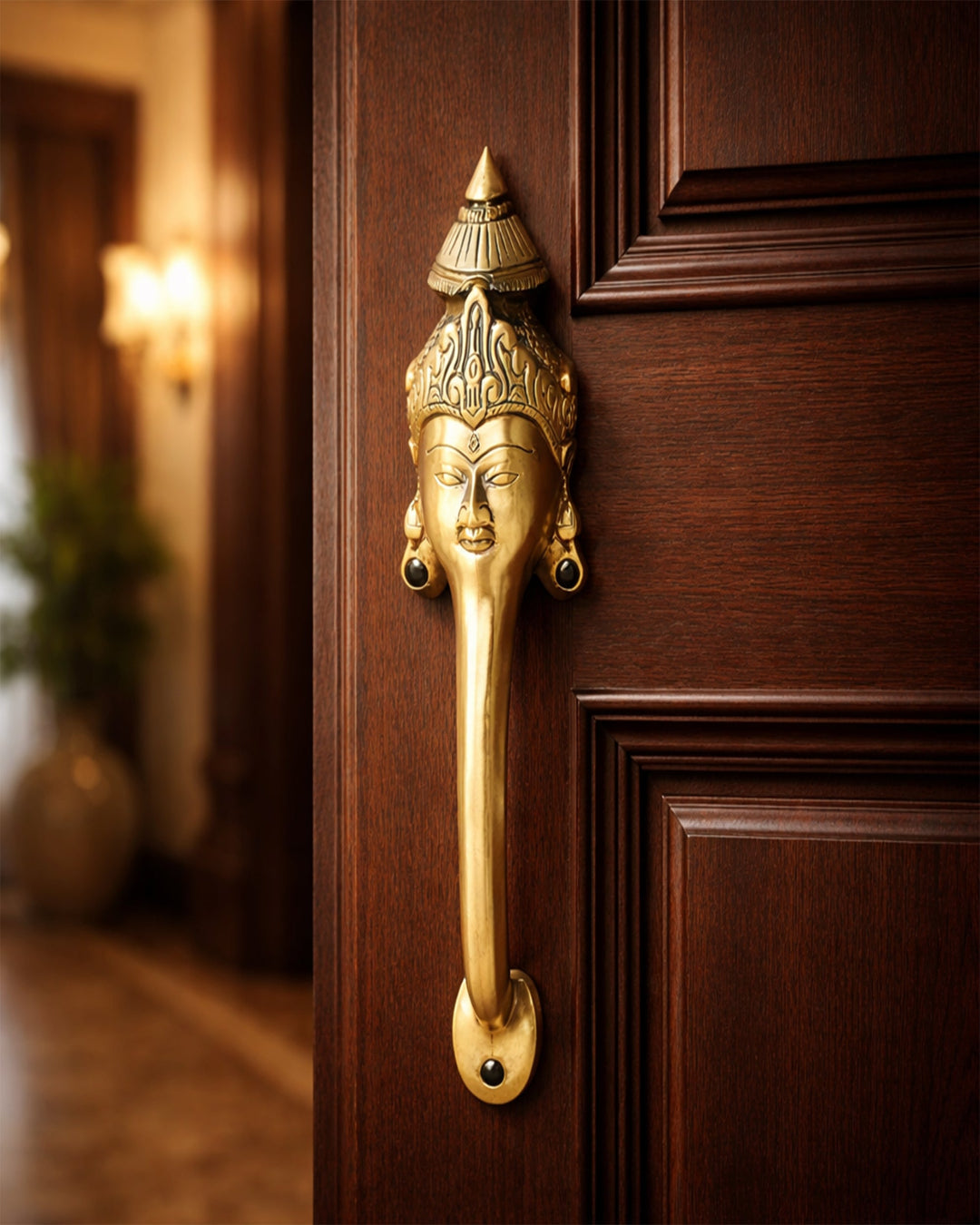 Decorative brass door handle on a wooden door.