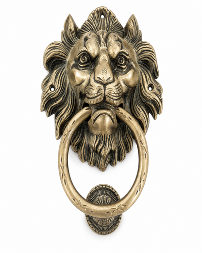 An antique-style lion head door knocker in a distressed bronze finish, featuring a detailed lion face with a ring pull and decorative mounting plate, shown against a plain white background.
