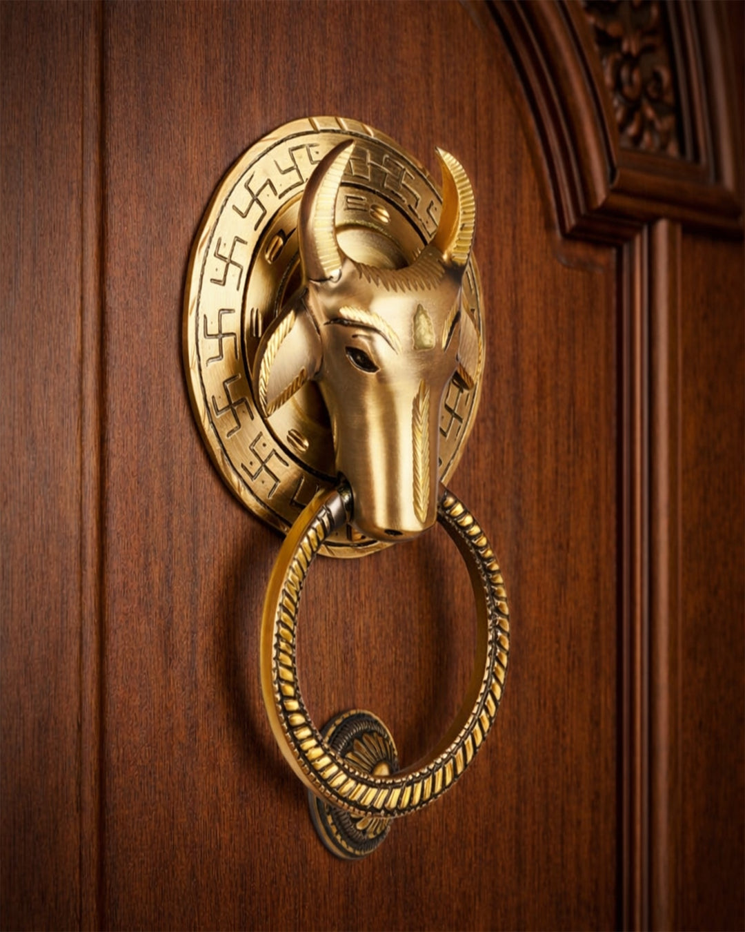 Gold door knocker with bull design on a wooden door